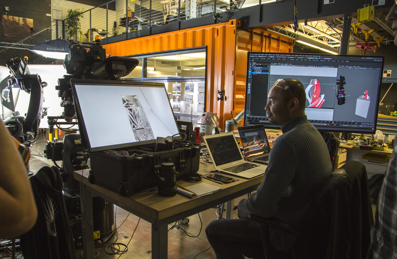 Autodesk工厂的一名工人正在检查多个电脑屏幕上的3D模型。