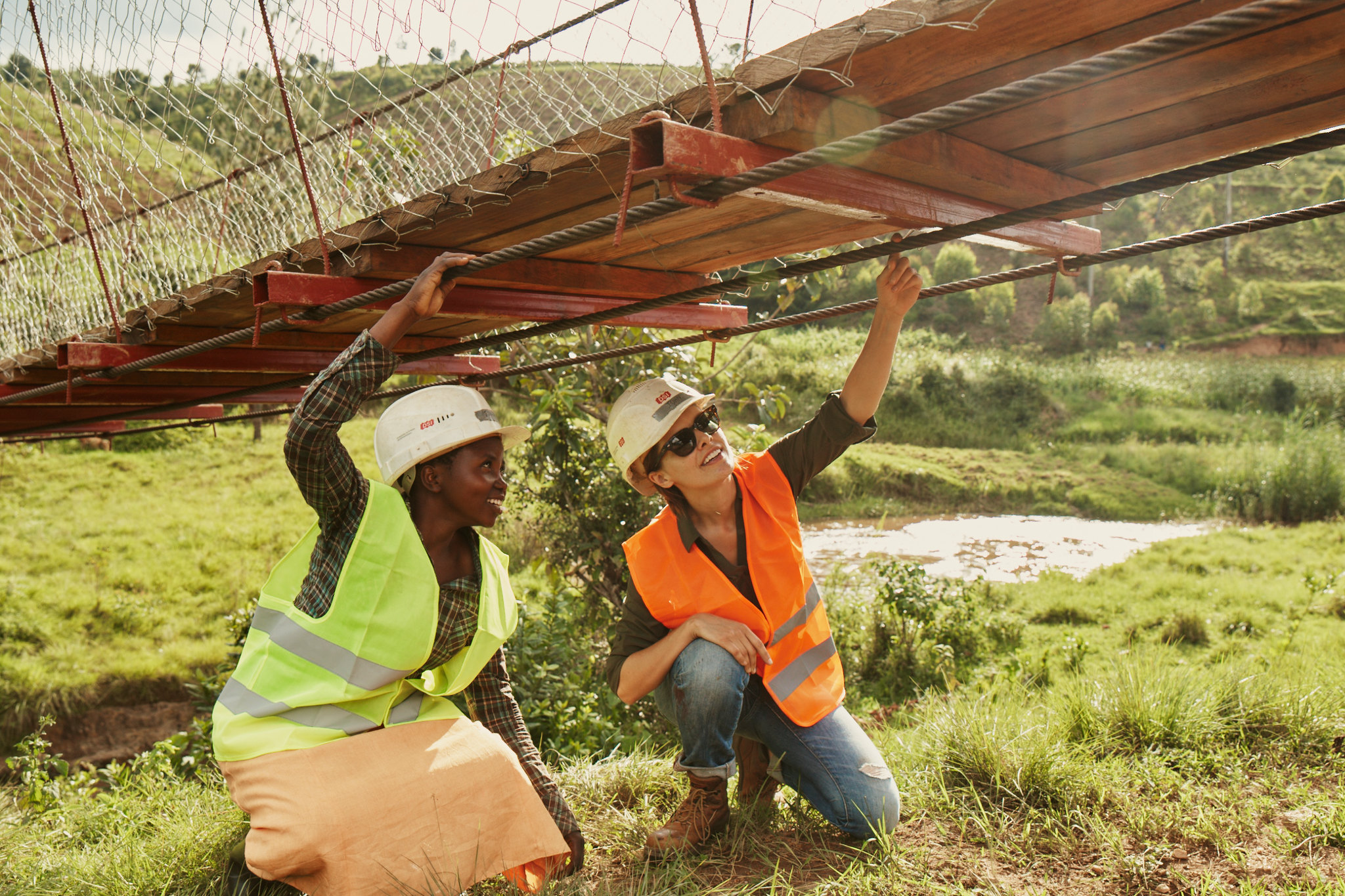 工程师们在卢旺达检查一座B2P步行桥的电缆。
