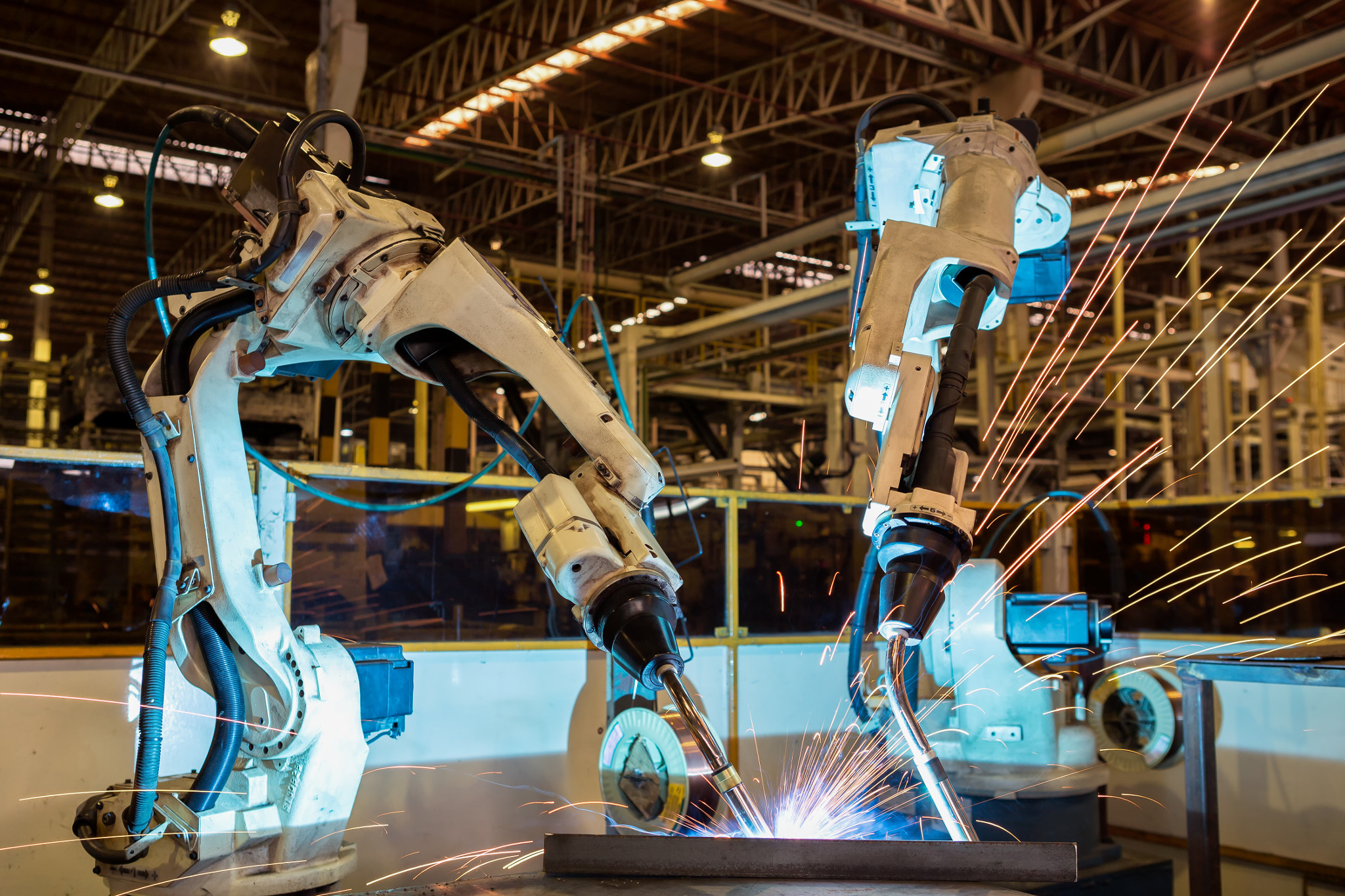 一队工业机器人在汽车工厂焊接。